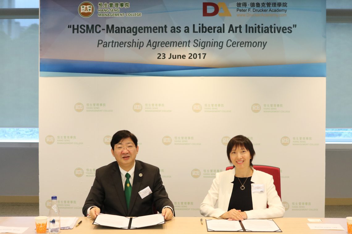 Professor Simon S.M. Ho (Left), President of Hang Seng Management College (HSMC) and Ms Julia Wang (Right) of President of Peter F. Drucker Academy (DAHK) of Hong Kong sign the ‘HSMC-Management as a Liberal Art Initiatives’ (MLAI), pioneering Management as a Liberal Art.