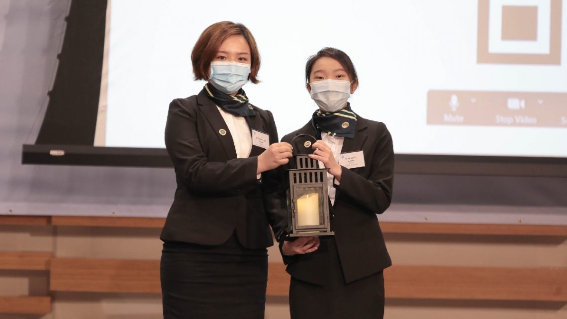 A simple yet solemn handover ceremony – Ms Anthea Chan (right), representative of the new Student Ambassadors, receives the lantern symbolising ‘passing on’ from her predecessor Ms Vivian Choi (left).