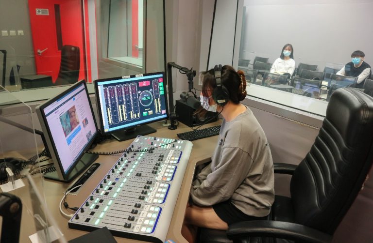 Students try out the broadcasting equipment in the Radio Broadcast Training Centre.[:hk[學生親身體驗電台廣播培訓中心內的廣播設備。
