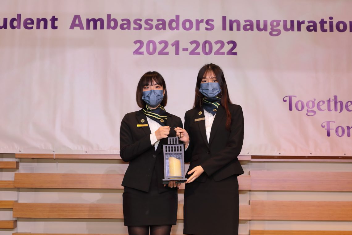 The simple yet solemn handover ceremony – Ms Yuki Liu Yeung-ki (right), the representative of the new cohort of Student Ambassadors, receives the lantern symbolising ‘passing on’ from her predecessor, Ms Myrna Lam.