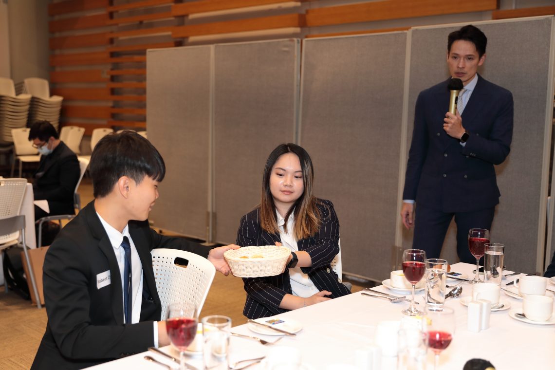 Students learn the proper etiquette of passing the bread basket around the table.