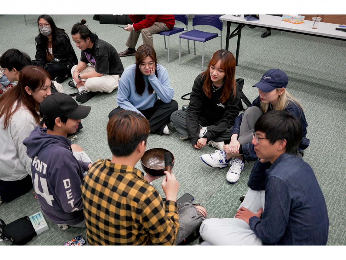 Students tapping on the Singing Bowl to relax and meditate.